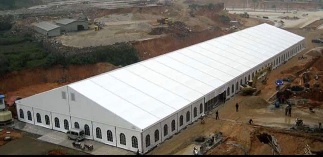 Aerial view of a massive white industrial-scale warehouse tent on a construction site